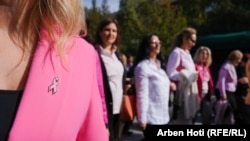 Женщины на акции по привлечению внимания к проблеме рака груди в Приштине 24 октября 2024 года. Розовая лента – международный символ борьбы с раком молочной железы
